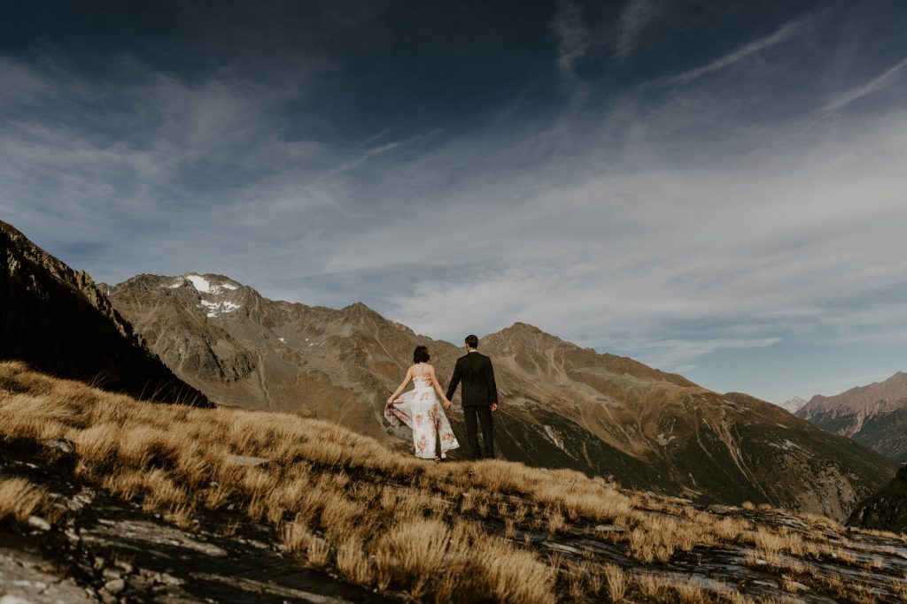 Bride and groom holding hands on top of glacier in Innsbruck, Austria